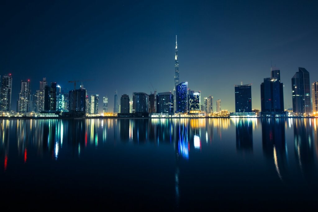 Gulf city skyline reflected in water at night